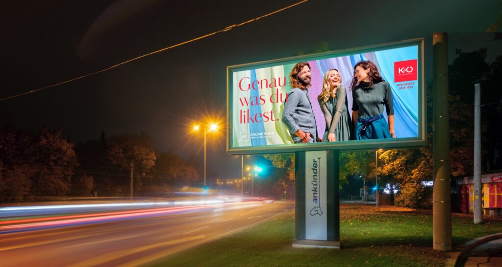 illuminated billboard with a clothing shop ad at night in Graz