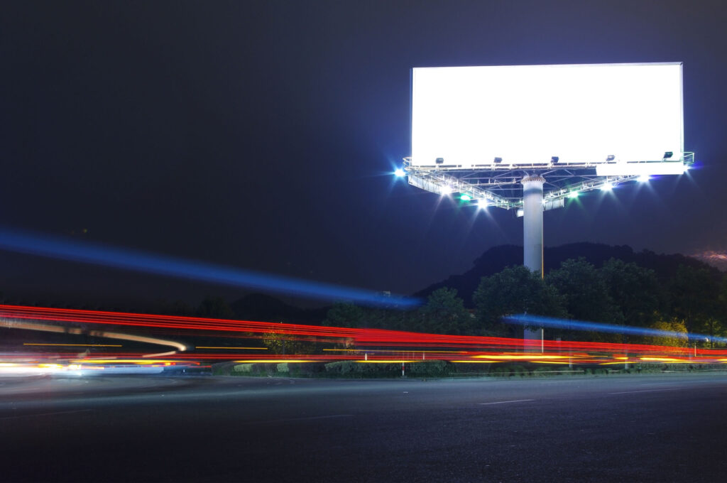 a bright billboard on a street at night